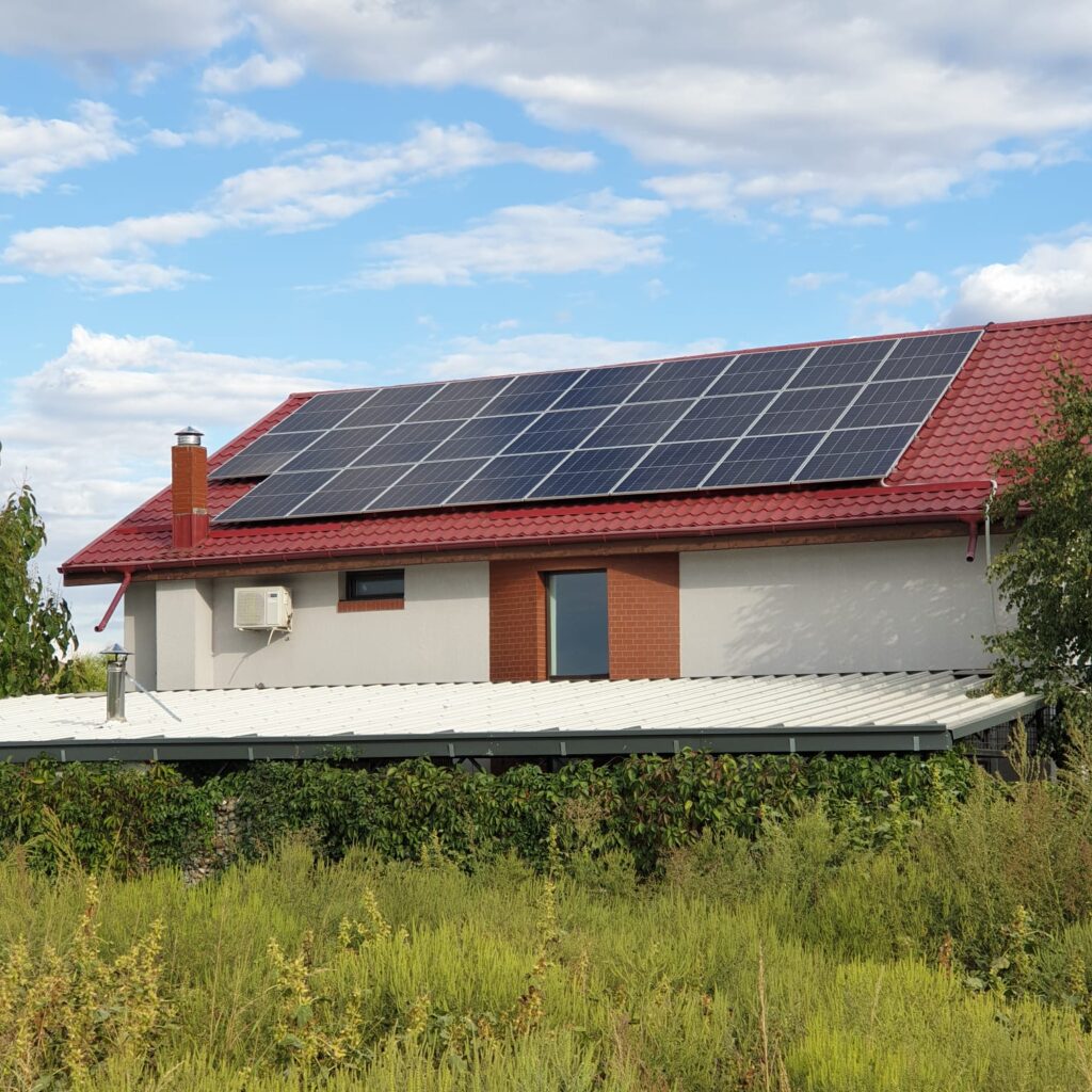 Casă pe al cărei acoperiș sunt montate panouri fotovoltaice.